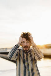 Portrait of staring man with hands on his hand at sunset - AFVF03354