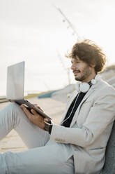 Businessman working on laptop outdoors - AFVF03373