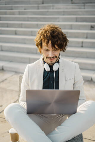 Geschäftsmann arbeitet an einem Laptop im Freien, lizenzfreies Stockfoto