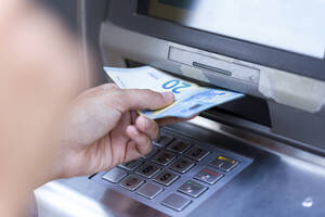Nahaufnahme einer Geschäftsfrau, die an einem Geldautomaten Geld abhebt - JSRF00307