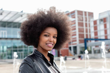 Young woman with afro hair on city concourse, portrait - CUF51458