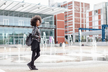 Coole junge Frau mit Afrofrisur in der Bahnhofshalle, in voller Länge - CUF51459