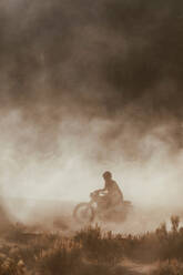 Motorbiker raising dust, Kennedy Meadows, California, US - ISF21748