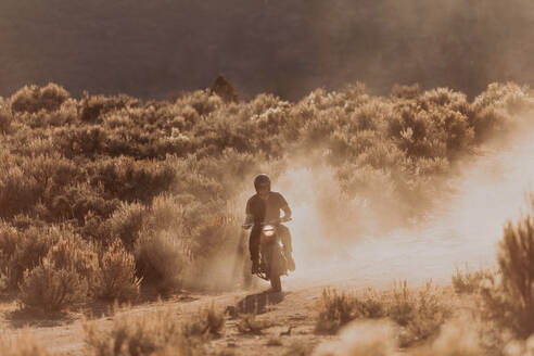 Motorradfahrer wirbelt Staub auf, Kennedy Meadows, Kalifornien, USA - ISF21750