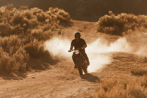 Motorradfahrer fährt durch die Landschaft von Kennedy Meadows, Kalifornien, USA - ISF21753