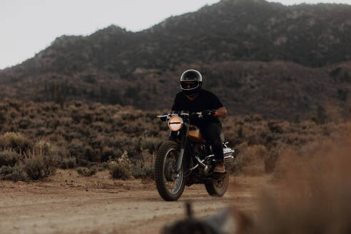 Motorradfahrer fährt durch die Landschaft von Kennedy Meadows, Kalifornien, USA - ISF21784