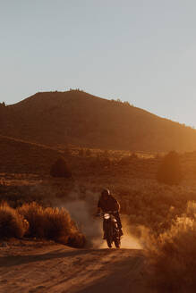 Motorradfahrer fährt durch die Landschaft von Kennedy Meadows, Kalifornien, USA - ISF21786