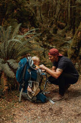 Wanderer mit Baby erkundet den Wald, Queenstown, Canterbury, Neuseeland - ISF21892