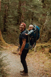 Wanderer mit Baby erkundet den Wald, Queenstown, Canterbury, Neuseeland - ISF21895