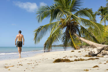 Mann geht an einem tropischen Strand entlang, Nationalpark Cahuita, Costa Rica - MAUF02606