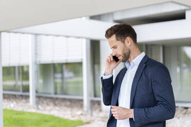 Geschäftsmann, der im Freien mit einem Handy telefoniert - DIGF07077