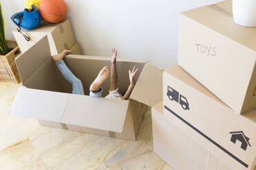 Unrecognisable girl inside cardboard box at new home - JPTF00179
