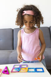 Girl playing with learning game at home - JPTF00205