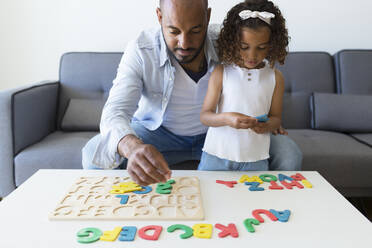 Vater und Tochter spielen mit dem Alphabet-Lernspiel zu Hause - JPTF00208