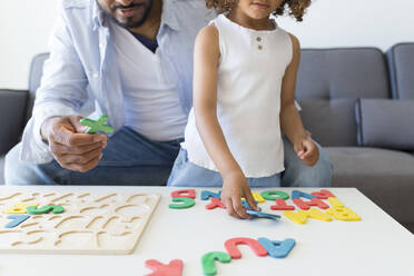 Vater und Tochter spielen mit dem Alphabet-Lernspiel zu Hause - JPTF00209