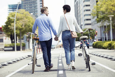 Couple with bikes in Barcelona, rear view - JSRF00346