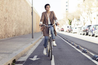 Woman with bike on bicycle lane in the city - JSRF00353