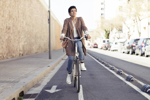 Frau mit Fahrrad auf dem Fahrradweg in der Stadt - JSRF00353