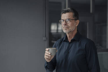 Portrait of mature businessman holding a cup - KNSF06071