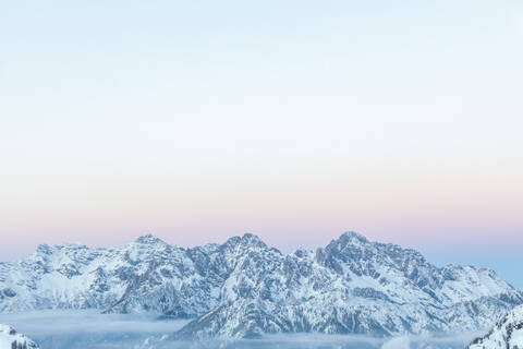 Blick über verschneite Berge mit Abendhimmel in der Abenddämmerung, Saalbach Hinterglemm, Pinzgau, Österreich, lizenzfreies Stockfoto