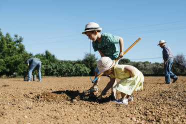Eine Familie bereitet an einem sonnigen Tag den Boden vor - JRFF03381