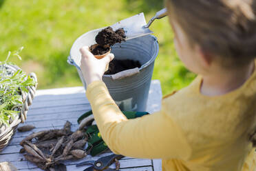 Girl gardening on garden table - MOEF02264