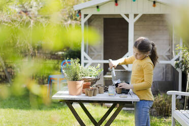 Girl gardening on garden table - MOEF02267