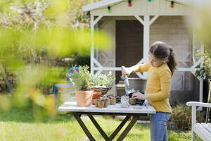 Mädchen bei der Gartenarbeit am Gartentisch - MOEF02267