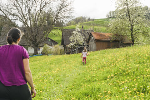 Mutter mit zwei Kindern beim Spaziergang auf einer Wiese in der Natur, lizenzfreies Stockfoto