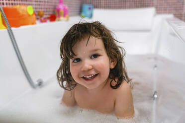 Portrait of happy little girl in bathtub - MGIF00538