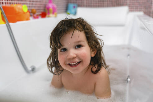 Porträt eines glücklichen kleinen Mädchens in der Badewanne - MGIF00538