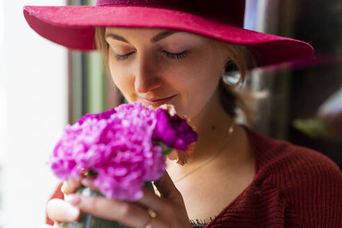 Junge Frau riecht an einer Blume - FBAF00798