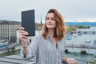 Young woman taking smartphone picture at Lake Zurich, Zurich, Switzerland - FBAF00803