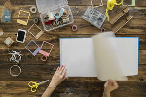 Top view of woman's hands preparing a scrapbook - SKCF00592