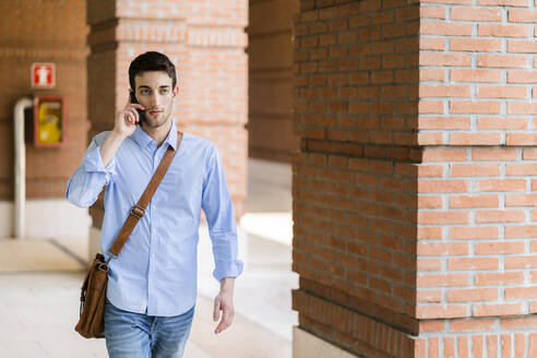 Junger Mann mit Smartphone in der Stadt - GIOF06511