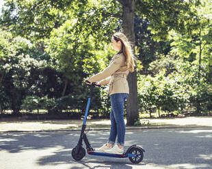 Lächelnde Frau auf E-Scooter - BFRF02029