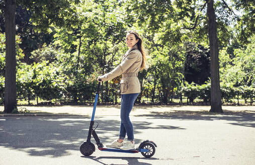 Portrait of smiling woman with E-Scooter - BFRF02031