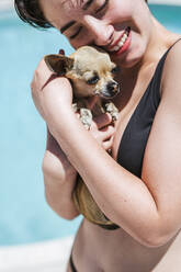 Junge Frauen mit Chihuahua am Pool - LJF00236