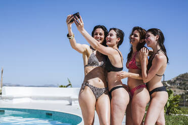 Junge Frauen, die den Sommer am Pool genießen und ein Selfie machen - LJF00254