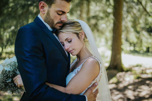 Romantische Braut und Bräutigam umarmen sich im Wald - ISF21942
