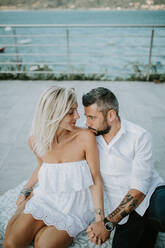 Romantisches erwachsenes Paar, das sich am Seeufer ansieht, Stresa, Piemonte, Italien - ISF21954