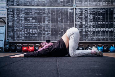 Junge Frau dehnt ihren Oberkörper im Fitnessstudio - ISF21995