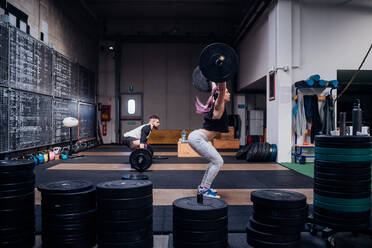 Young couple lifting barbell in gym - ISF22008