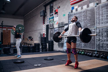 Junges Paar hebt Langhantel im Fitnessstudio - ISF22014