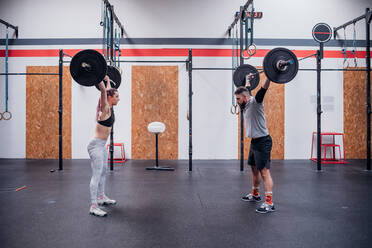 Junges Paar hebt Langhantel im Fitnessstudio - ISF22055