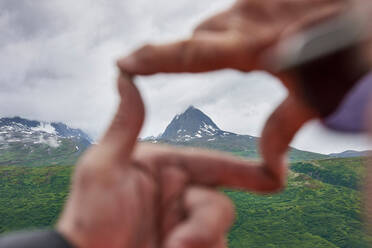 Älterer Mann und Sohn rahmen Berggipfel mit Händen ein, Nahaufnahme, Valdez, Alaska, USA - ISF22075