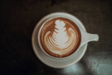 Tasse Mokka mit Muster auf dem Kaffeetisch, Blick von oben - ISF22101