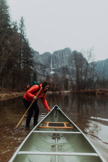 Junge Kanufahrerin zieht Kanu im Fluss, Yosemite Village, Kalifornien, USA - ISF22115