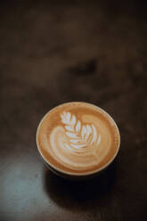 Tasse Milchkaffee mit Blattmuster auf dem Tresen eines Cafés, Draufsicht - ISF22132