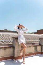 Frau auf dem Dach in modischem weißen Kleid - AFVF03431